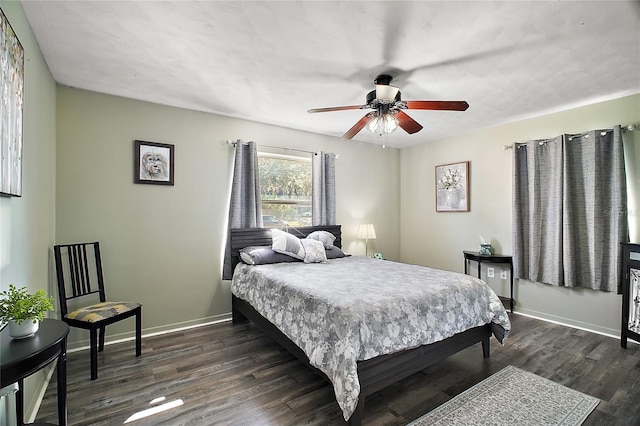 bedroom featuring dark wood-type flooring, ceiling fan, and baseboards