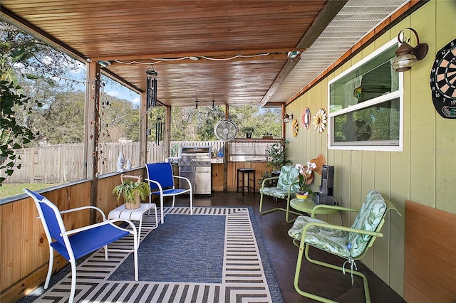 view of patio with a bar, area for grilling, and fence