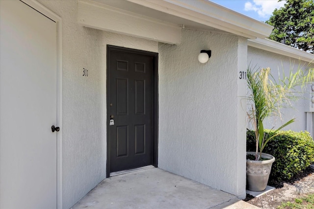 view of exterior entry featuring stucco siding