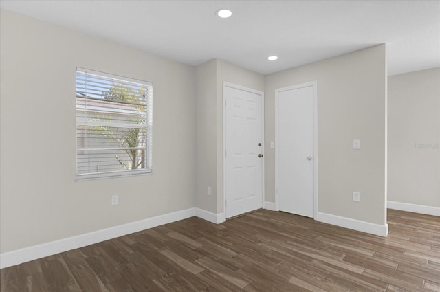 unfurnished bedroom with baseboards, wood finished floors, and recessed lighting