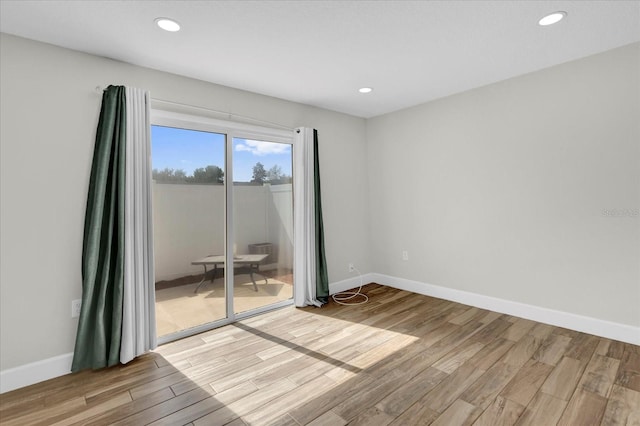 empty room with recessed lighting, light wood-style flooring, and baseboards