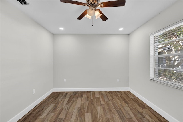 spare room featuring dark wood-type flooring, recessed lighting, visible vents, and baseboards