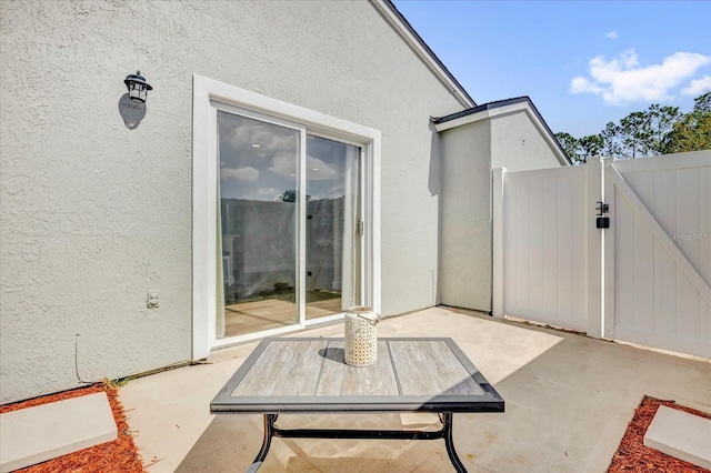 view of patio featuring fence and a gate