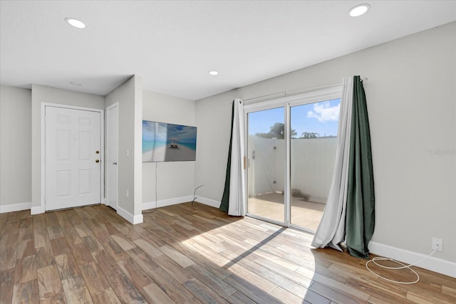 unfurnished room featuring recessed lighting, wood finished floors, and baseboards