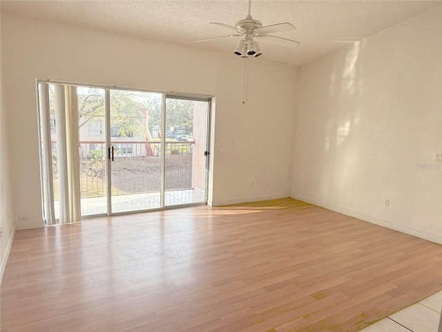 empty room featuring a textured ceiling, baseboards, a ceiling fan, and light wood-style floors