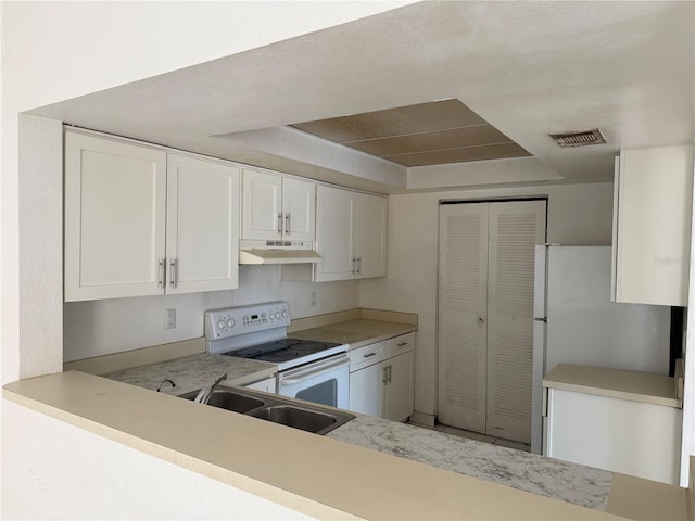 kitchen featuring white appliances, light countertops, under cabinet range hood, white cabinetry, and a sink