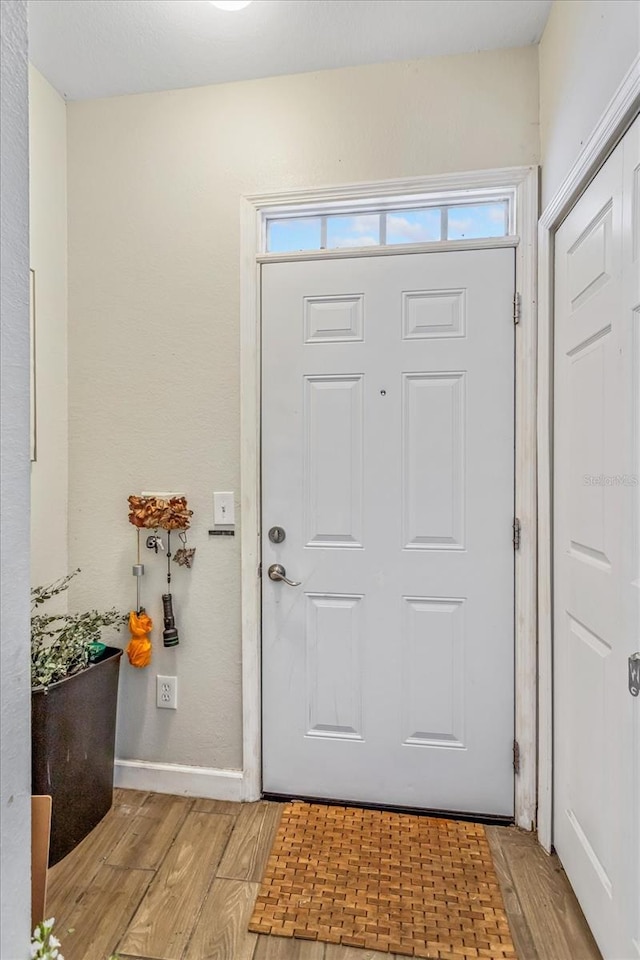 foyer with light wood-type flooring and baseboards