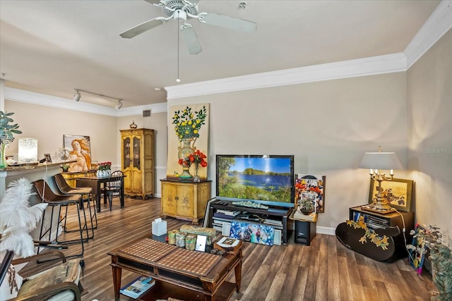 living room featuring crown molding, rail lighting, ceiling fan, wood finished floors, and baseboards