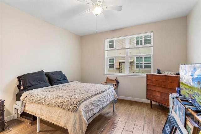 bedroom with a ceiling fan, baseboards, and wood finished floors