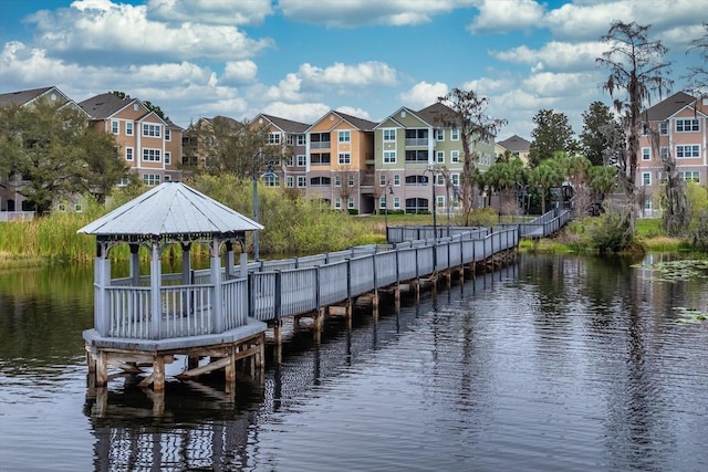 view of dock featuring a water view, a residential view, and a gazebo