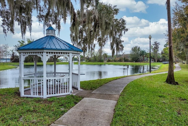 view of property's community featuring a water view, a lawn, and a gazebo