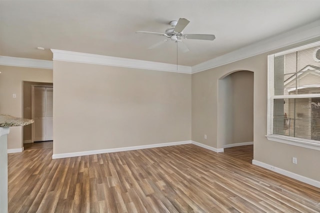 3368 Parkchester Square Blvd Unit 104, Orlando, FL 32835 - empty room with crown molding, arched walkways, light wood-style flooring, baseboards, and ceiling fan