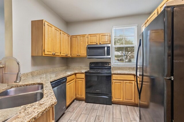 3368 Parkchester Square Blvd Unit 104, Orlando, FL 32835 - kitchen with stainless steel appliances, a sink, light stone countertops, and light wood-style floors