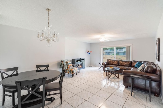 dining area featuring light tile patterned floors, a textured ceiling, and ceiling fan with notable chandelier