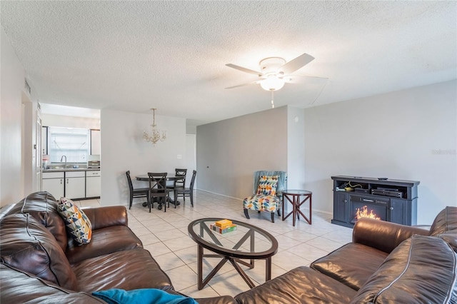 living room with light tile patterned floors, a warm lit fireplace, a textured ceiling, and a ceiling fan