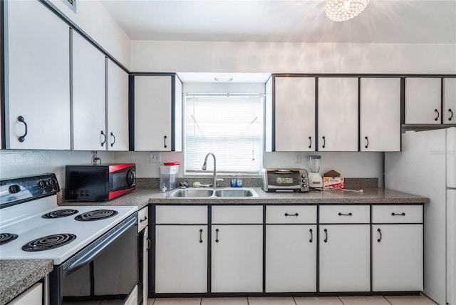 kitchen with range with electric stovetop, dark countertops, a sink, and white cabinets