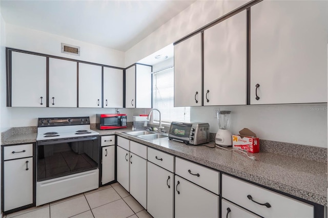 kitchen featuring range with electric stovetop, light tile patterned floors, visible vents, white cabinetry, and a sink