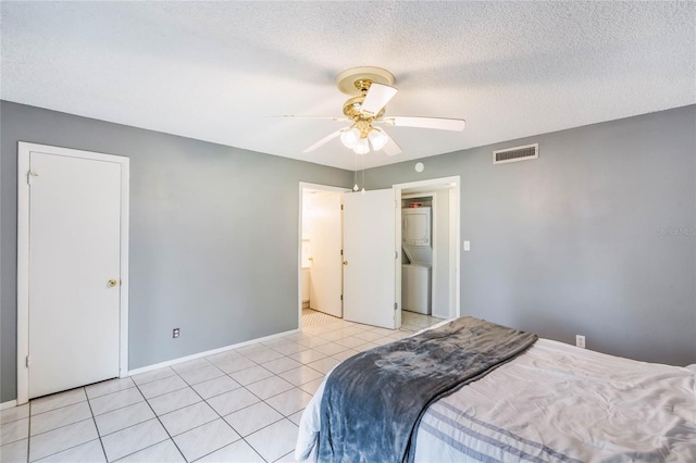 bedroom with a textured ceiling, ceiling fan, light tile patterned flooring, visible vents, and baseboards