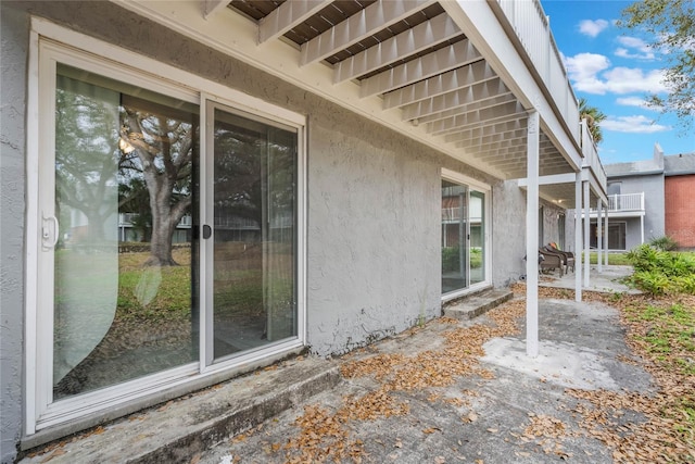 view of side of property featuring a patio and stucco siding