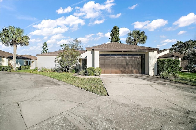 view of front of property featuring concrete driveway, an attached garage, and stucco siding