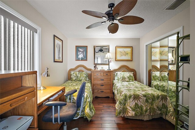 bedroom with visible vents, wood-type flooring, ceiling fan, a textured ceiling, and a closet