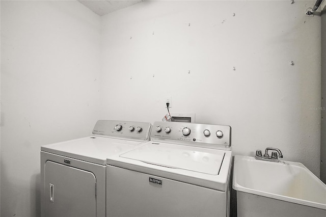 washroom with laundry area, independent washer and dryer, and a sink