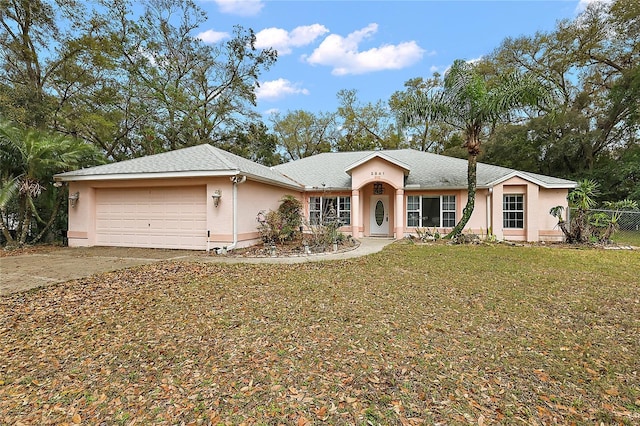 single story home featuring stucco siding, driveway, an attached garage, and a front lawn