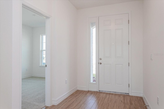 foyer with light wood finished floors and baseboards