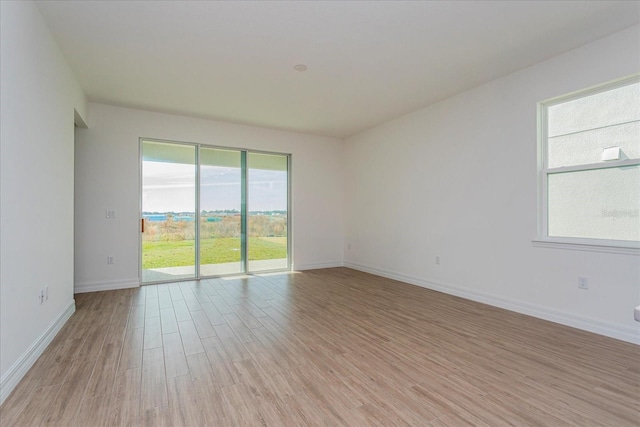 empty room with baseboards and light wood-style floors