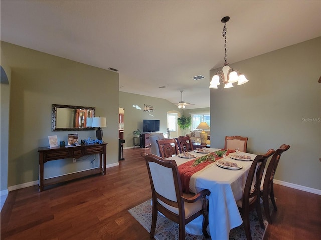 dining area featuring dark wood-style floors, visible vents, vaulted ceiling, baseboards, and ceiling fan with notable chandelier