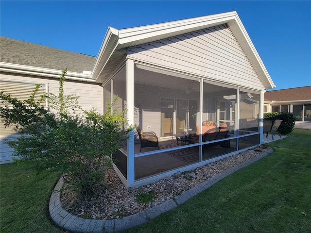 rear view of property with a sunroom and a lawn