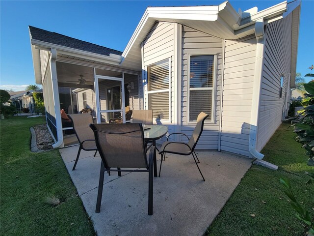 view of patio / terrace with a sunroom, ceiling fan, and outdoor dining area