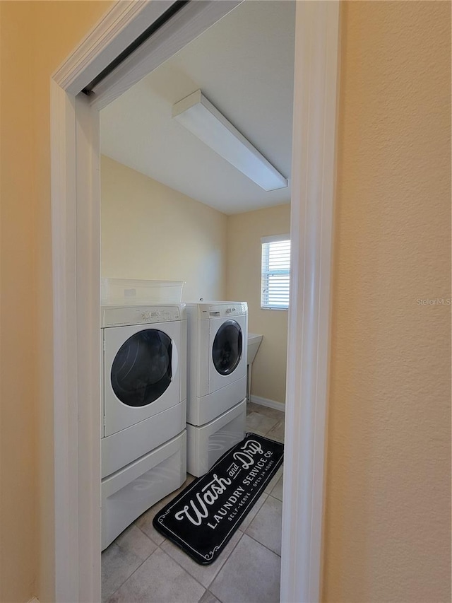 washroom featuring washing machine and dryer, laundry area, and tile patterned flooring