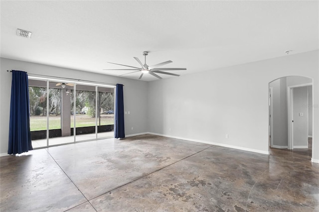 unfurnished room with baseboards, concrete floors, arched walkways, and ceiling fan