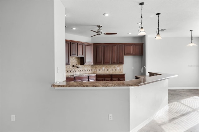 kitchen featuring pendant lighting, visible vents, decorative backsplash, a ceiling fan, and a peninsula