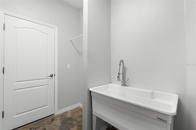 bathroom featuring unfinished concrete flooring and a sink