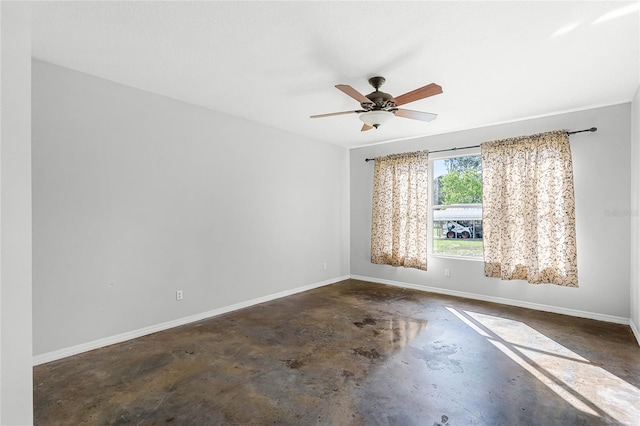 unfurnished room featuring concrete floors, baseboards, and a ceiling fan