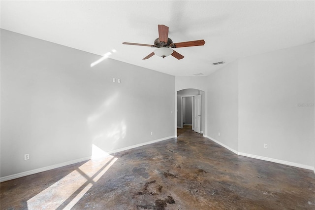 empty room with arched walkways, visible vents, a ceiling fan, concrete floors, and baseboards