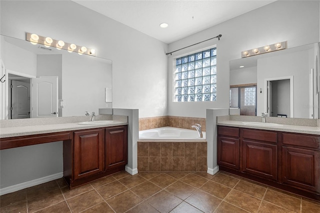 bathroom featuring tile patterned flooring, visible vents, a sink, and a bath