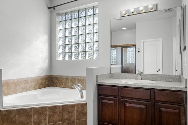 bathroom with a garden tub and vanity