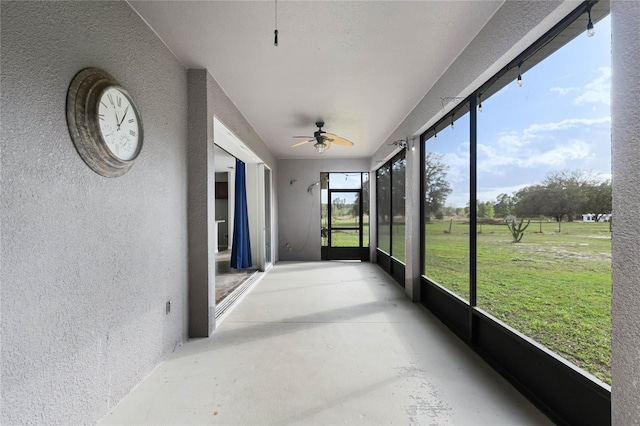 unfurnished sunroom featuring ceiling fan