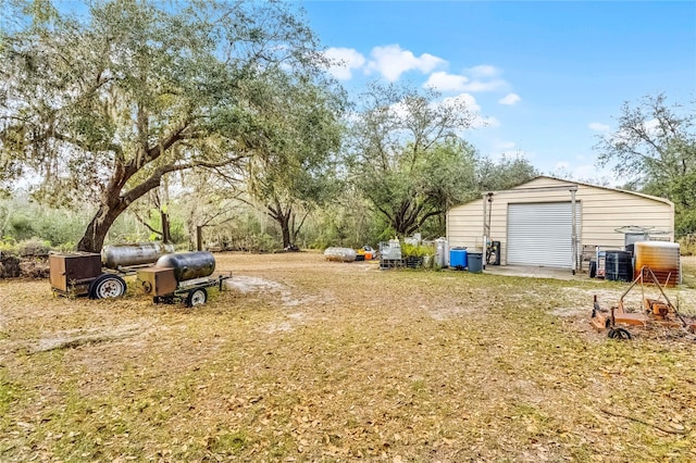 view of yard featuring a garage, an outbuilding, and central AC