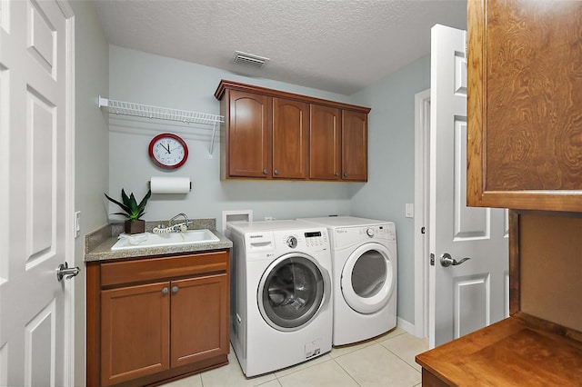 washroom featuring light tile patterned floors, cabinet space, visible vents, a sink, and separate washer and dryer