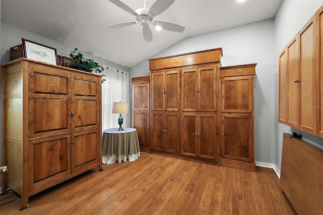 interior space with light wood-type flooring, ceiling fan, baseboards, and vaulted ceiling