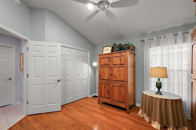 interior space featuring ceiling fan, baseboards, vaulted ceiling, a closet, and light wood-type flooring