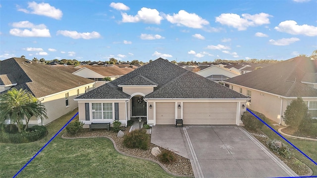 single story home with an attached garage, driveway, roof with shingles, stucco siding, and a front yard