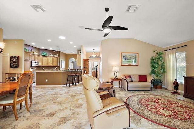 living area featuring lofted ceiling, ceiling fan, and visible vents