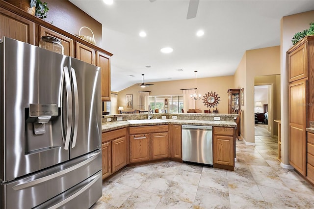 kitchen featuring ceiling fan with notable chandelier, stainless steel appliances, a sink, and lofted ceiling