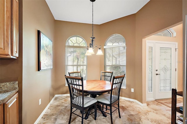 dining space featuring a chandelier and baseboards