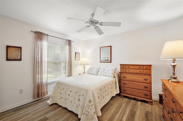 bedroom featuring baseboards, ceiling fan, and light wood-style floors